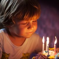 Kind hat einen Geburtstagskuchen mit Kerzen
